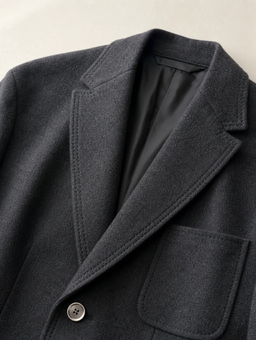Close-up of hand-stitched notch lapel and horn buttons